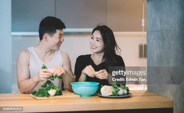 asian chinese couple preparing food in the kitchen - raw food diet stock pictures, royalty-free photos & images