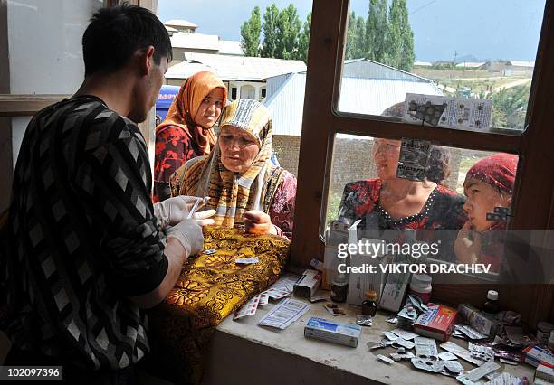 Ethnic Uzbek refugees recieve medication at the Kyrgyz-Uzbek border outside the village of Suratash some 15 km to the south of Osh on June 14, 2010....