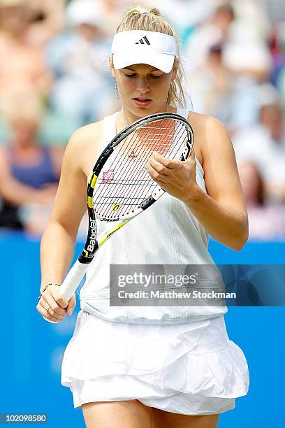 Caroline Wozniacki of Denmark adjusts her racquet between points against Aravane Rezai of France druing the AEGON International at Devonshire Park on...