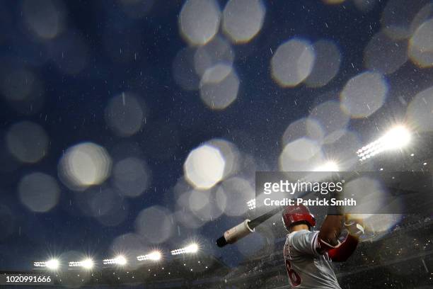 Rain falls as Cesar Hernandez of the Philadelphia Phillies prepares to bat against the Washington Nationals during the third inning at Nationals Park...