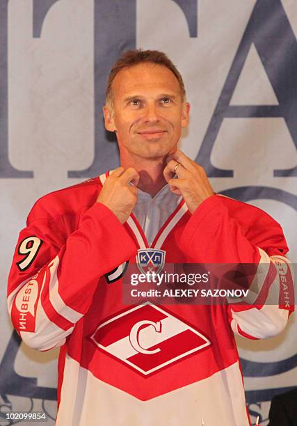 Legendary Czech NHL ice hockey goaltender Dominik Hasek puts on the jersey of Spartak Moscow, in Moscow on June 7, 2010 after signing a contract to...
