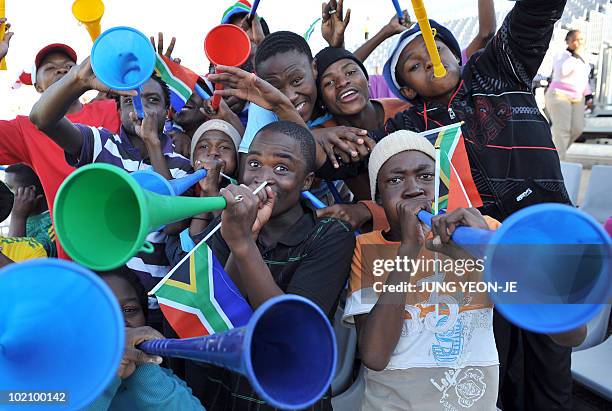 South African fans cheer and blow "vuvuzela" horns before the England football team takes on local team Platinum Stars FC in a training exhibition...