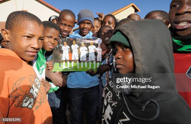 Kids from the SOS Children's Village pose with a poster of the England team on June 15, 2010 in Rustenburg, South Africa.