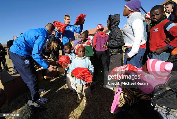 Michael Dawson and Matthew Upson hand out shirts to children from the SOS Children's Village project on June 15, 2010 in Rustenburg, South Africa.