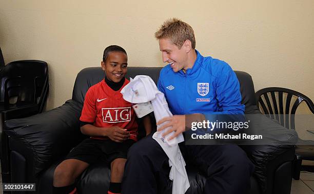 Michael Dawson presents a signed England shirt to Aubrey from the SOS Children's Village on June 15, 2010 in Rustenburg, South Africa.