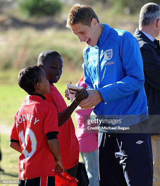 Michael Dawson signs autographs for children from the SOS Children's Village project on June 15, 2010 in Rustenburg, South Africa.