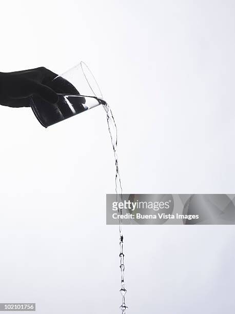 hand holding a glass with a water splash - fülle stock-fotos und bilder