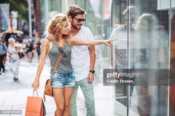 erwachsenen australischen paar shopping in der city - window shopping stock-fotos und bilder