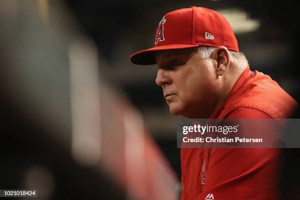 Manager Mike Scioscia of the Los Angeles Angels watches from the dugout during the third inning of the MLB game against the Arizona Diamondbacks at...