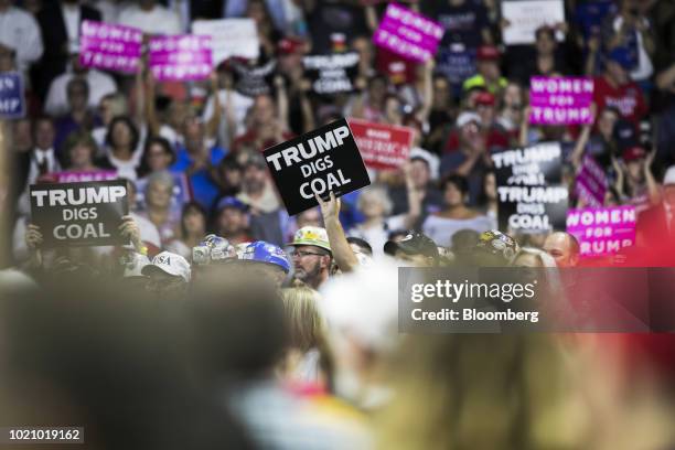 Attendees hold up placards reading "Trump Digs Coal" during a rally with U.S. President Donald Trump in Charleston, West Virginia, U.S., on Tuesday,...