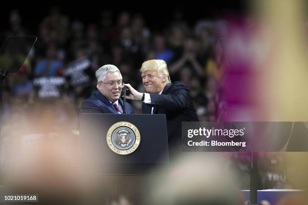 President Donald Trump, right, adjusts a microphone for Attorney General Patrick Morrisey, Republican U.S. Senate candidate from West Virginia,...