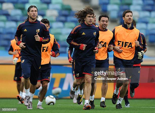 Carles Puyol of Spain runs with Sergio Ramos , Xabi Alonso and other teammates during a training session at the Moses Mabhida Stadium on June 15,...
