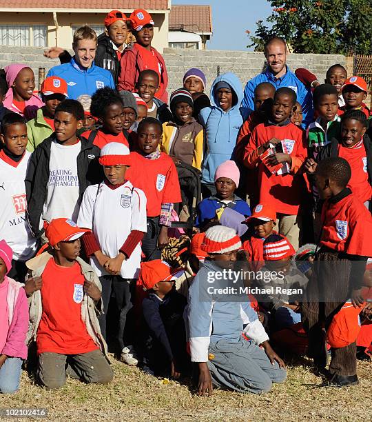 Michael Dawson and Matthew Upson pose with children from the SOS Children's Village project on June 15, 2010 in Rustenburg, South Africa.