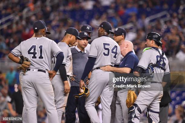 Teammates and trainers visit with Aroldis Chapman of the New York Yankees on the mound after Chapman was injured throwing a pitch in the twelfth...