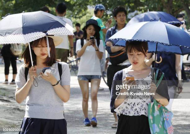 Photo taken on July 23, 2016 shows women playing the "Pokemon Go" smartphone game in a park in Osaka. ==Kyodo