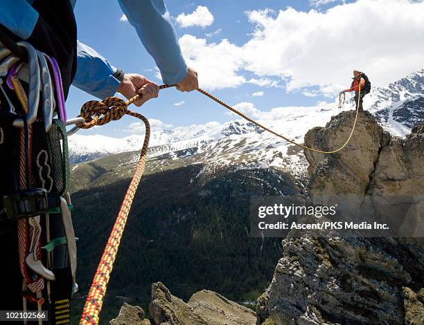 climber pulls rope tight to teammate on mtn ridge - mountain ridge stock pictures, royalty-free photos & images