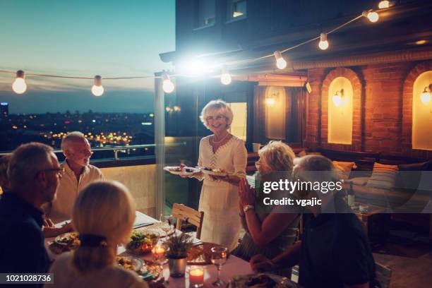 senior rooftop dinner party - 50s diner stock pictures, royalty-free photos & images