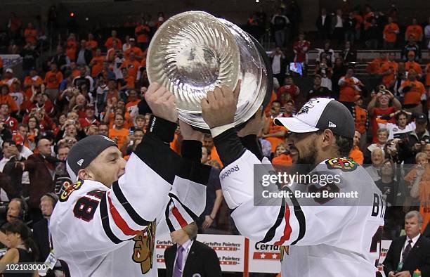 Patrick Kane and Dustin Byfuglien of the Chicago Blackhawks share the Stanley Cup after the Blackhawks defeated the Philadelphia Flyers 4-3 in...