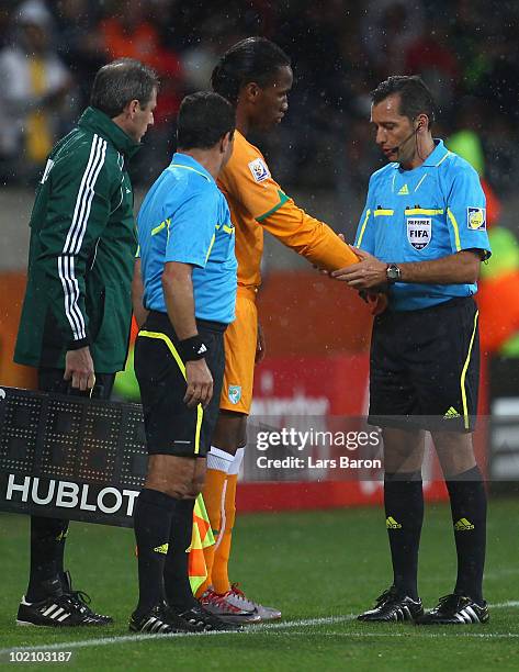 Referee Jorge Larrionda checks the cast under the sleeve of Didier Drogba of Ivory Coast before he comes onto the pitch as a substitute during the...