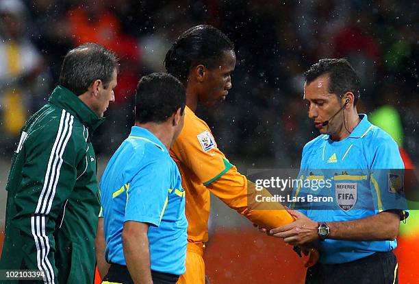 Referee Jorge Larrionda checks the cast under the sleeve of Didier Drogba of Ivory Coast before he comes onto the pitch as a substitute during the...