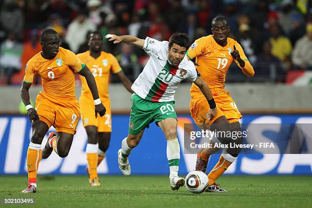 Deco of Portugal is challenged by Ismael Tiote and Yaya Toure of Ivory Coast during the 2010 FIFA World Cup South Africa Group G match between Ivory...