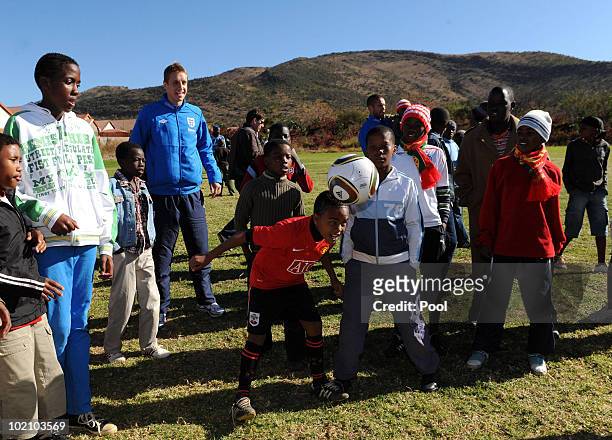 Englands Michael Dawson watches Aubrey aged 12 from the SOS Children's Village project on June 15, 2010 in Tlhabane Township near Rustenburg, South...