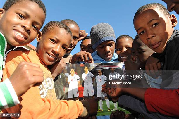 Children with an England poster as Michael Dawson and Matthew Upson visit children from the SOS Children's Village project on June 15, 2010 in...