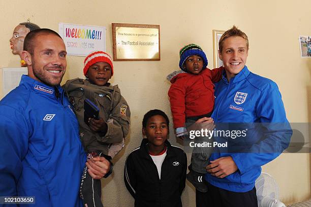 Englands Michael Dawson and Matthew Upson with Muzi aged 3 Able aged 13 during a visit to the SOS Children's Village project on June 15, 2010 in...