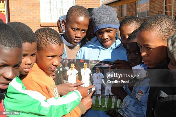 Children with an England poster as Michael Dawson and Matthew Upson visit children from the SOS Children's Village project on June 15, 2010 in...