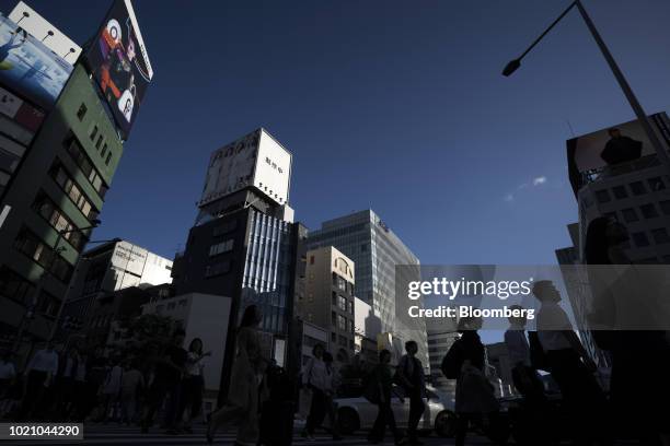 Pedestrians cross a road in the Omotosando area of Tokyo, Japan, on Tuesday, Aug. 21, 2018. Japan is scheduled to release February's Consumer Price...