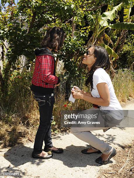 Actress Rosario Dawson greets a child attending the Environmental Media Association and Yes to Carrots Garden Luncheon at The Learning Garden at...
