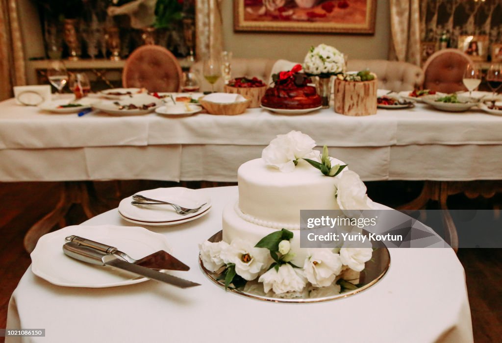 Celebratory cake white on a table with cutlery