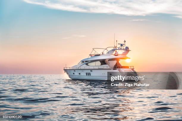 en la puesta de sol - small boat ocean fotografías e imágenes de stock