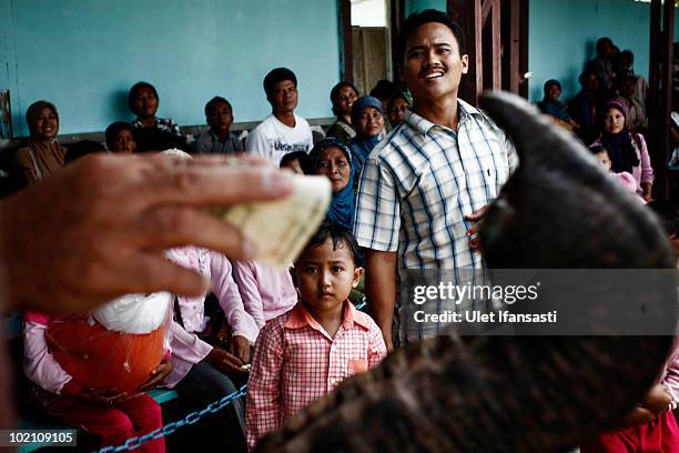 Visitors give donations to Sumatran trained elephant during a circus performance, aside from their role as patrol elephants searching for illegal...