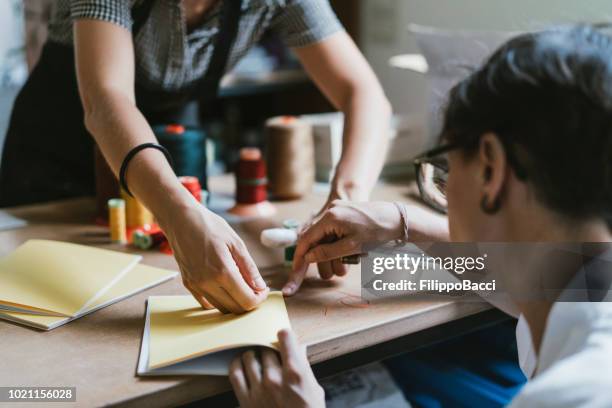 young adult woman making a notebook - book binding stock pictures, royalty-free photos & images