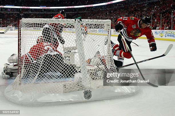 Marian Hossa of the Chicago Blackhawks trips over Scott Hartnell of the Philadelphia Flyers in front of the net of Antti Niemi of the Blackhawks in...