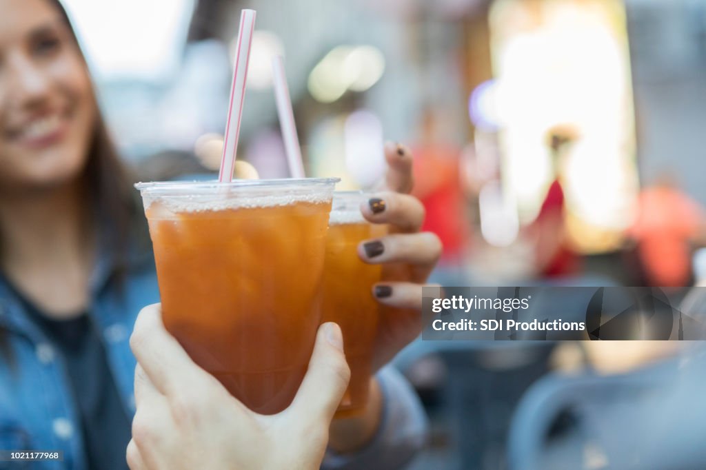 Young couple toast cold drinks while on vacation