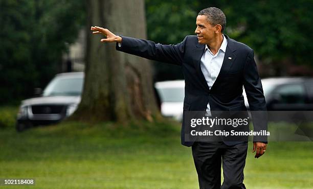 President Barack Obama waves to guests while walking across the White House South Lawn after arriving from an overnight trip to the Gulf Coast June...