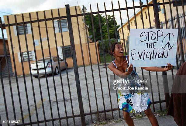 Ashaundre Young carries a sign reading, "Stop the eviction," during a protest againt the evictions being carried out at the apartment complex in...