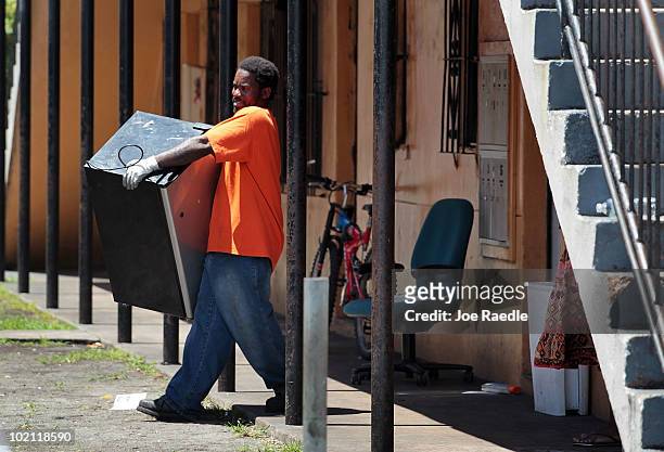 Worker for an eviction company carries belongings out of an apartment after the residents were evicted on June 15, 2010 in Miami, Florida. A small...