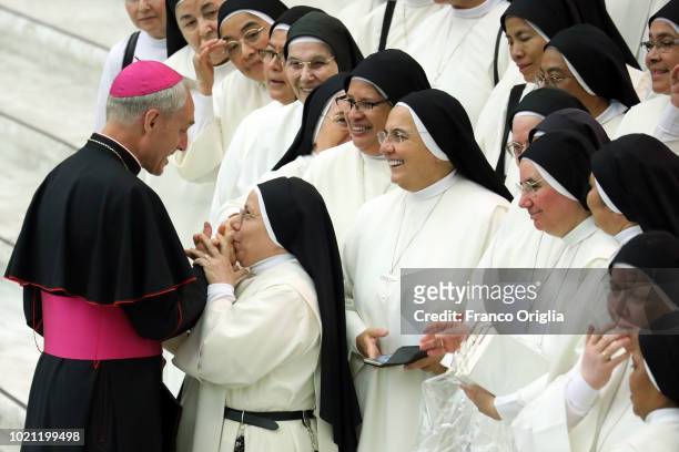 Nun kisses the hand of Prefect of the Pontifical House Georg Ganswein during Pope Francis' weekly audience at the Paul VI Hall on August 22, 2018 in...