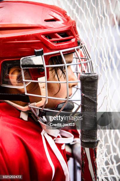 young girl ice hockey player in red equipment - center ice hockey player stock pictures, royalty-free photos & images