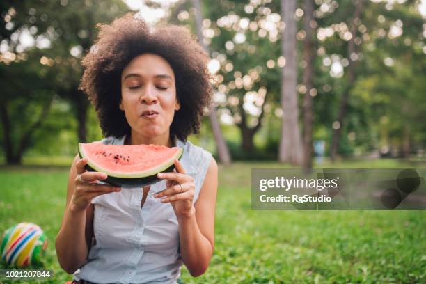 frau isst wassermelone im freien - kauen stock-fotos und bilder