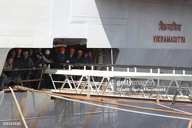 Workers stand aboard the INS Vikramaditya , a modified former Kiev class aviation cruiser at the Sevmash shipyard June 15, 2010 in the Northern...