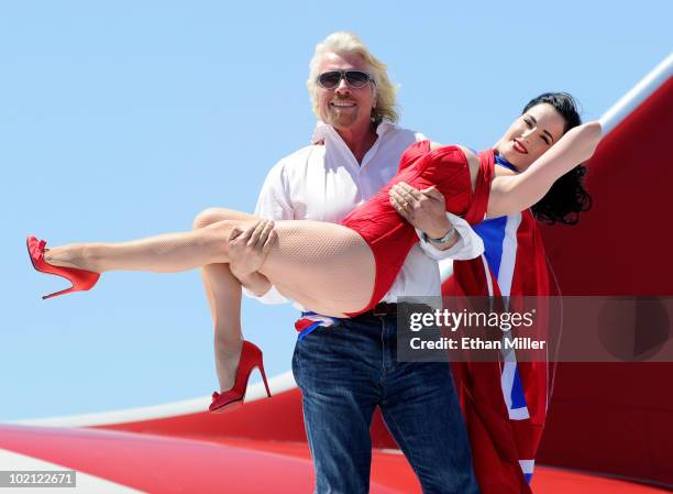 Founder and President of Virgin Group Sir Richard Branson holds burlesque artist Dita Von Teese as they appear on the wing of a Virgin Atlantic...