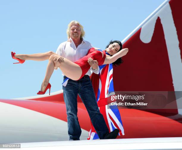 Founder and President of Virgin Group Sir Richard Branson holds burlesque artist Dita Von Teese as they appear on the wing of a Virgin Atlantic...