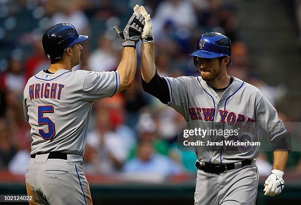 David Wright of the New York Mets congratulates teammate Ike Davis after he hit a two run home run against the Cleveland Indians during the game on...