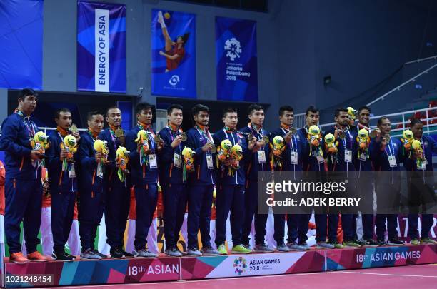 India's sepak takraw athletes pose for photographers after winning bronze medal in the men's team regu at the 2018 Asian Games in Palembang on August...