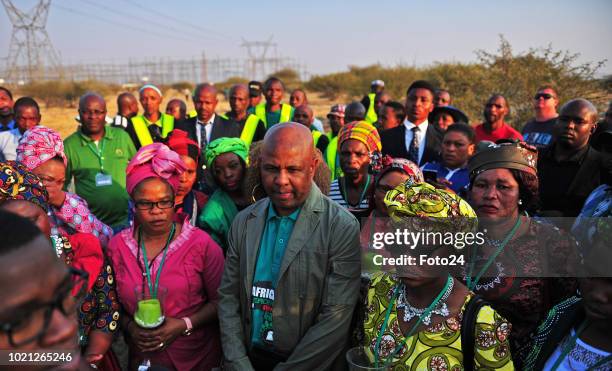 Association of Mineworkers and Construction Union president Joseph Mathunjwa is flanked by widows and family members of the 34 slain miners during an...
