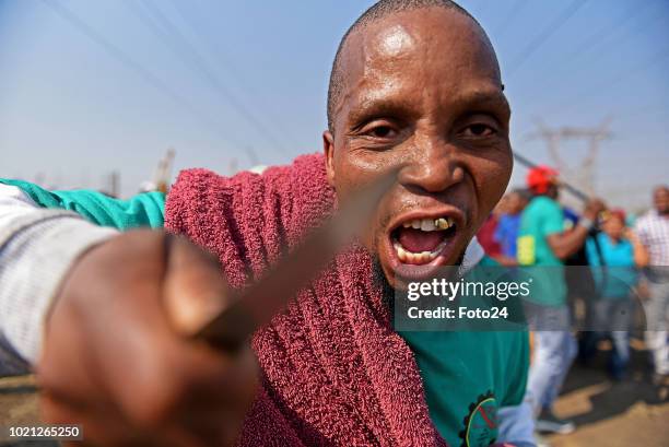 Miners sing and chant gather during an event to commemorate the sixth anniversary of the Marikana massacre on August 16, 2018 in Rustenburg, South...